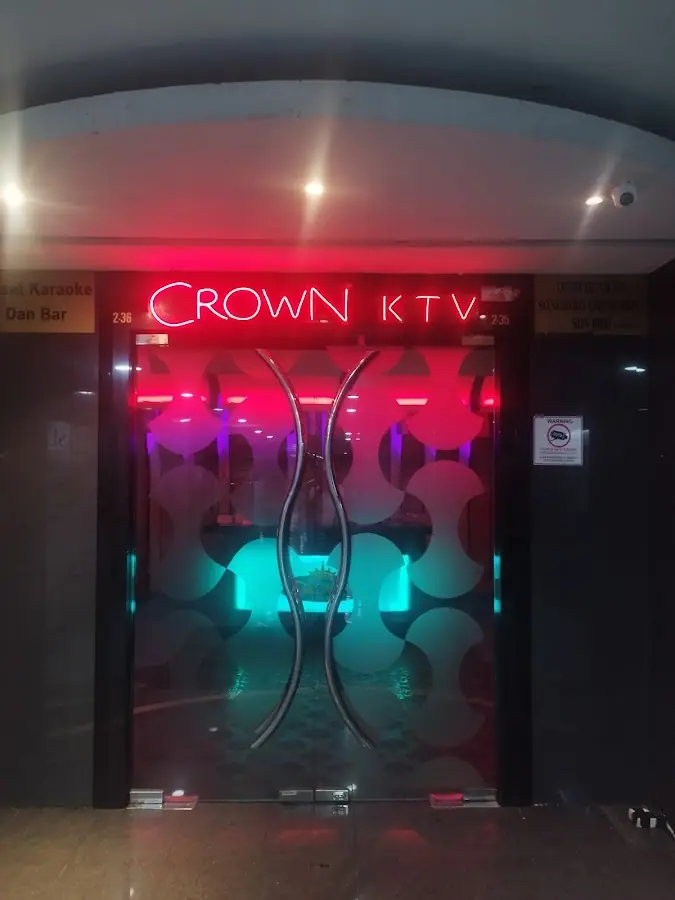 Crown KTV: Glass-door entrance with red neon 'CROWN KTV' sign, unit 2.36 inside Plaza Berjaya