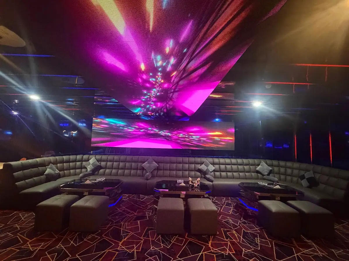 D Babylon Club: KTV room with long sofa, ottomans and pink-purple LED ceiling